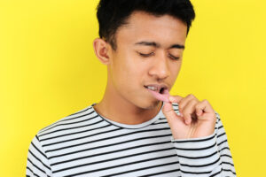 man nursing canker sore in mouth