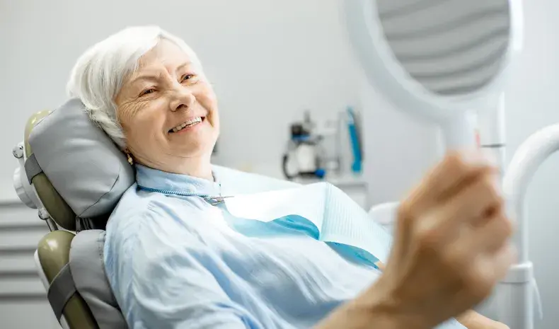 older woman seeing her new smile at the dentist