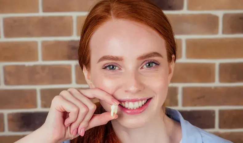 woman holding a fake tooth