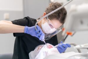 dentist with air abrasion tool