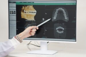 Dental professional analyzing digital radiography images on a monitor, showcasing advanced imaging technology for modern dental practices.
